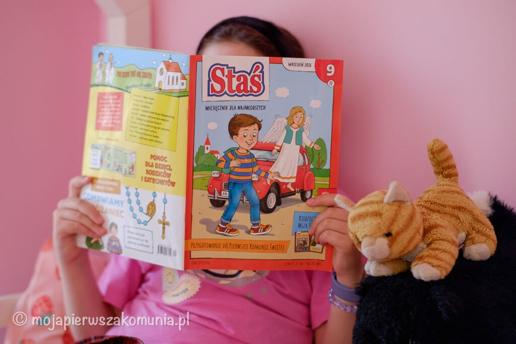 Dziewczynka czyta gazetkę „Staś”, katolicki miesięcznik dla dzieci
