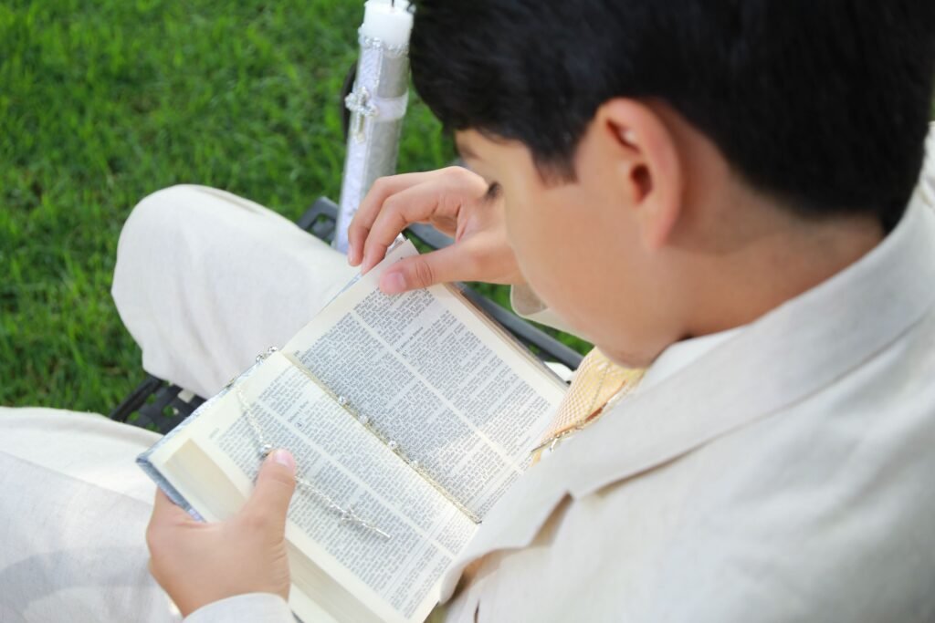 Chłopiec czyta Biblię, Przygotowuje się do pierwszej Komunii